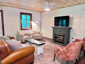 ein Wohnzimmer mit Kamin und Fernseher in der Unterkunft Close to Lake Blue Ridge, Hot Tub, Swing Beds in Morganton