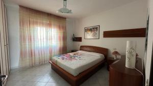 a small bedroom with a bed and a window at Poetto Casa Bach Ck in Quartu SantʼElena