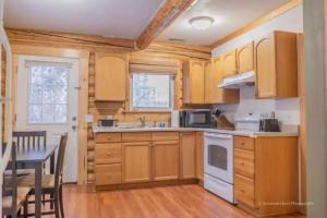a kitchen with wooden cabinets and a table and a dining room at Cabin in the woods Fairbanks, Alaska, United States in Fairbanks