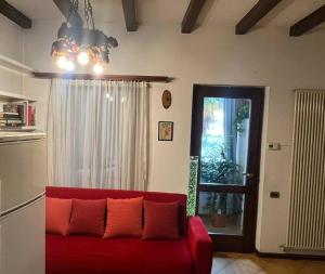 a living room with a red couch and a window at Benedetta in Chiavenna