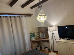 a living room with a television and a chandelier at Benedetta in Chiavenna