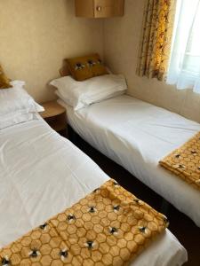 two twin beds in a room with a window at 613 Promenade, Ingoldmells in Ingoldmells