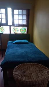 a bedroom with a bed with a blue blanket and two windows at Apartamento en Chicó Norte in Bogotá