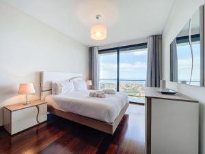 a bedroom with a large bed and a large window at Villa Ribeiro Real 12 A in Câmara de Lobos