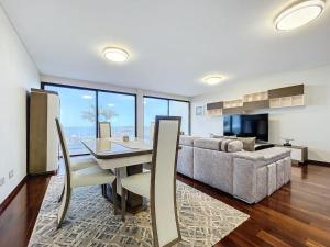 a living room with a table and a couch at Villa Ribeiro Real 12 A in Câmara de Lobos