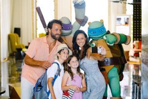 a family posing for a picture in front of a costume at Nickelodeon Hotels & Resorts Punta Cana - Gourmet All Inclusive by Karisma in Punta Cana