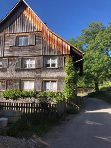 a wooden house with a fence in front of it at Ursprungshaus - Nuss und Traube in Dornbirn