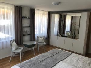 a bedroom with a large mirror and a table and chairs at Ursprungshaus - Nuss und Traube in Dornbirn