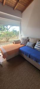 una camera da letto con due letti e una finestra di Monte das Romas a Charnequinha Altre 3 foto