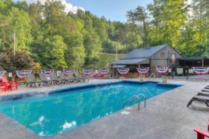 a swimming pool with chairs and a barn at Misty Mountain Sunrise in Sevierville