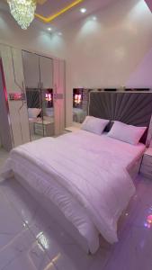 a bedroom with a large white bed with a large mirror at ASimmo in Dakar