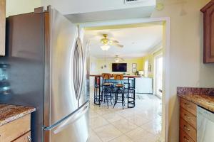 a kitchen with a refrigerator and a table with chairs at Fortuna Sea Brisas Condominiums #4 in Corpus Christi