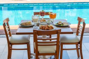 a table with plates of food and drinks next to a pool at Hotel Tres Soles in Ciudad Madero
