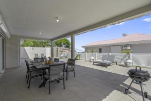 a dining room with a table and chairs on a patio at Villa Loiseau des îles in Les Anses-dʼArlets