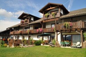 un gran edificio con balcones, mesas y flores en Landhaus Harmonie, en Arnbruck