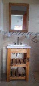 een badkamer met een wastafel en een spiegel bij Cabañas Tinkuy I in Cortaderas