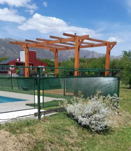 een tennisbaan met een houten pergola in een veld bij Cabañas Tinkuy I in Cortaderas