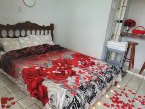 a bedroom with a bed with red roses on it at Unidades 1 e 2 e 3 Pousada do Sossego Mar e Verde in Itanhaém +112 photos