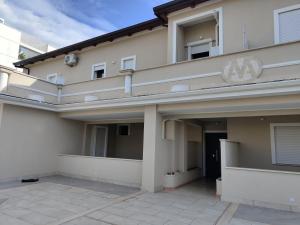 a large white building with a patio in front of it at Villa A&M 10 Mansarda Vip in Latina