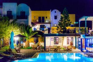 a resort with a swimming pool at night at Kalimera Hotel in Akrotiri