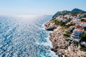 a group of houses on a cliff next to the ocean at Blue Views Villa with Heated Pool & Jacuzzi in Dubrovnik +44 photos
