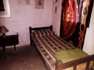 a small bed in a room with a curtain at La Revuelta in Amaicha del Valle