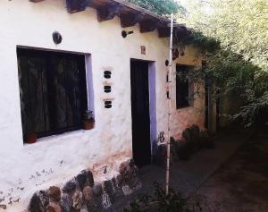 a house with a black door and a window at La Revuelta in Amaicha del Valle