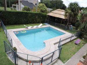 a large swimming pool in a yard with a gazebo at Cabañas Las Lomas in Juana Koslay 