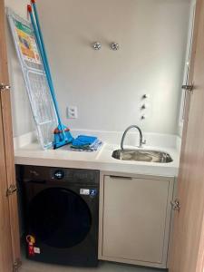 Il comprend une petite cuisine équipée d'un évier et d'un lave-vaisselle. dans l'établissement Apartamento novo em Foz, ao lado do Shopping JL, à Foz do Iguaçu