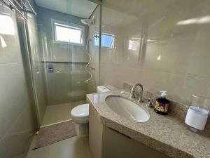 une salle de bain avec un lavabo, une douche et des toilettes dans l'établissement Apartamento novo em Foz, ao lado do Shopping JL, à Foz do Iguaçu 28 autres photos