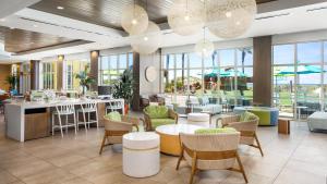 a restaurant with tables and chairs and windows at Holiday Inn Resort Fort Walton Beach by IHG in Fort Walton Beach