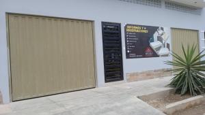 a building with a gate and a sign on the wall at Monte Negro Hospedaje in La Victoria