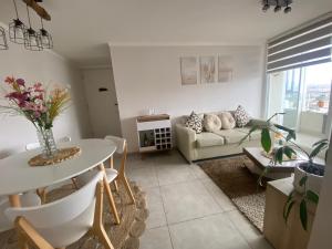 ein Wohnzimmer mit Sofa und Tisch in der Unterkunft Hermoso y amplio Departamento frente al mar in Coquimbo