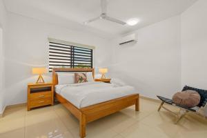 a bedroom with a bed with two lamps and a chair at Yanti at Nightcliff - Foreshore - Pool - Shops & Cafe in Nightcliff +28 photos