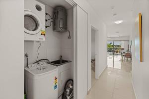 a laundry room with a washer and a washing machine at Yanti at Nightcliff - Foreshore - Pool - Shops & Cafe in Nightcliff