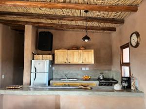 Casa rural con vistas a la Cordillera y Precordillera في Villa Pituil: مطبخ مع ثلاجة ومغسلة