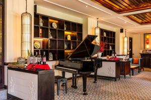 a grand piano in a lobby with a bar at Wyndham Garden Hoi An Cua Dai Beach in Hoi An