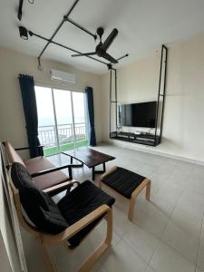 サンダカンにあるThe Cove Homestay Sandakan - seaviewのテーブルと椅子とテレビのあるリビングルーム +14枚の写真