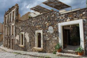 an old stone building with a door and a window at Hotel El Ángel y El Corazón in Real de Catorce
