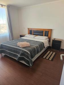a bedroom with a bed with a blanket on it at Hermoso y cómodo departamento en edificio in Calama