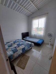 GuamoにあるCasa en condominio Guamo Tolimaのベッドルーム1室(ベッド1台、ファン付きの窓付) +14枚の写真