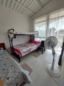 GuamoにあるCasa en condominio Guamo Tolimaのベッドルーム1室(ベッド1台、ファン付)