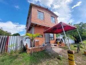 GuamoにあるCasa en condominio Guamo Tolimaの大きな赤い傘が前にある家