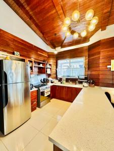 a kitchen with a stainless steel refrigerator and wooden walls at Casa Victoriana Aeropuerto in San Juan Arriba
