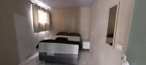 a bed in a white room with a window at Casa temporada Araçoiaba in Araçoiaba