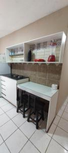 a kitchen with a counter and a table in it at Casa temporada Araçoiaba in Araçoiaba