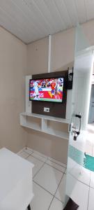 a television on a wall in a room at Casa temporada Araçoiaba in Araçoiaba