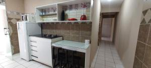 a small kitchen with a stove and a refrigerator at Casa temporada Araçoiaba in Araçoiaba