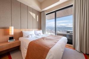 a hotel room with a bed and a large window at Niseko Kyo in Kutchan +30 photos