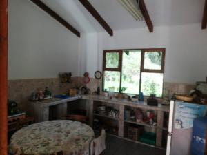 Zimmer mit einer Küche mit einem Tisch und einem Kühlschrank. in der Unterkunft Casa en el campo in Quillacollo